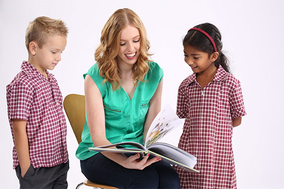 Students reading with a teacher